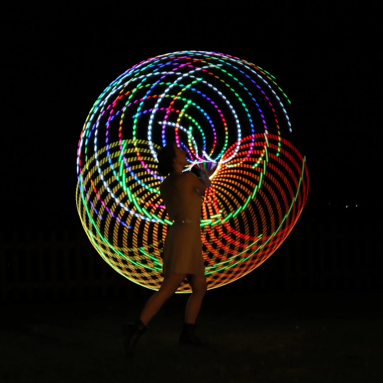 ragazza fa roteare i led nel buio creando un gioco di luci affascinante