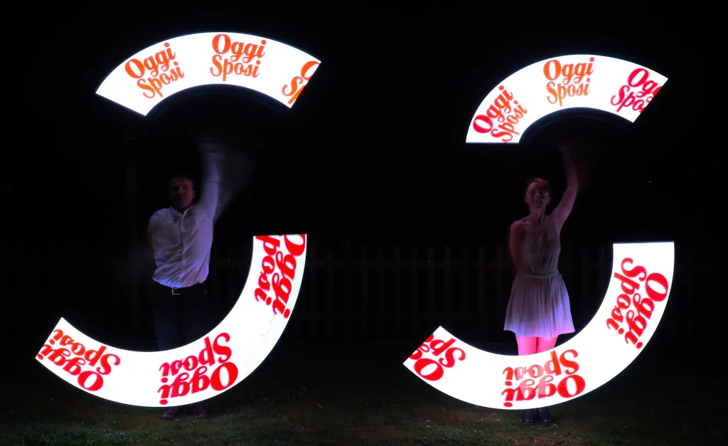 elvis e la sua compagna durante uno spettacolo con led le luci per un matrimonio. Appare la scritta luminosa: oggi sposi.