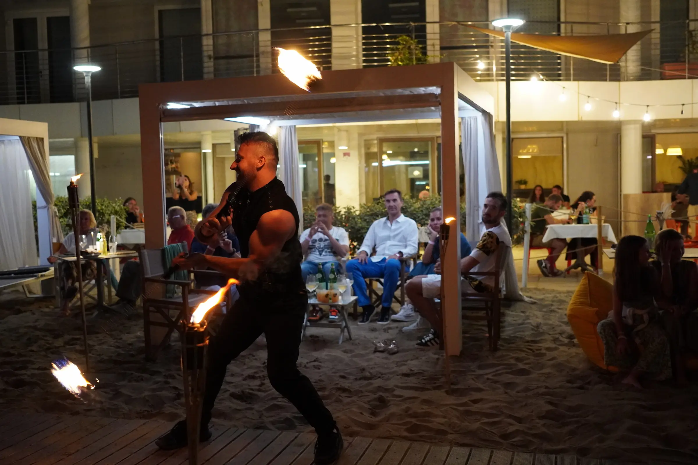 Elvis durante uno spettacolo con fuoco sulla spiaggia