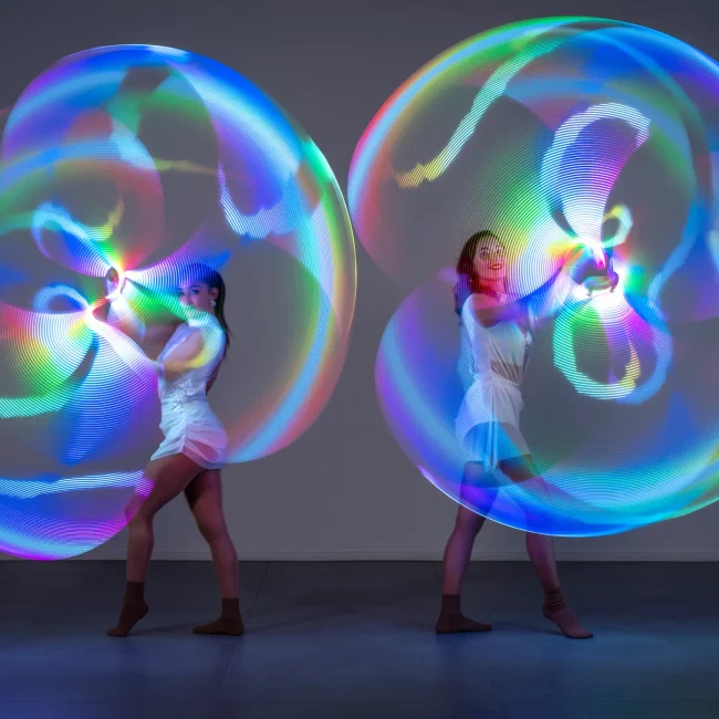 due ragazze del team di artharex si esibisce con led luminoso formando due cerchi