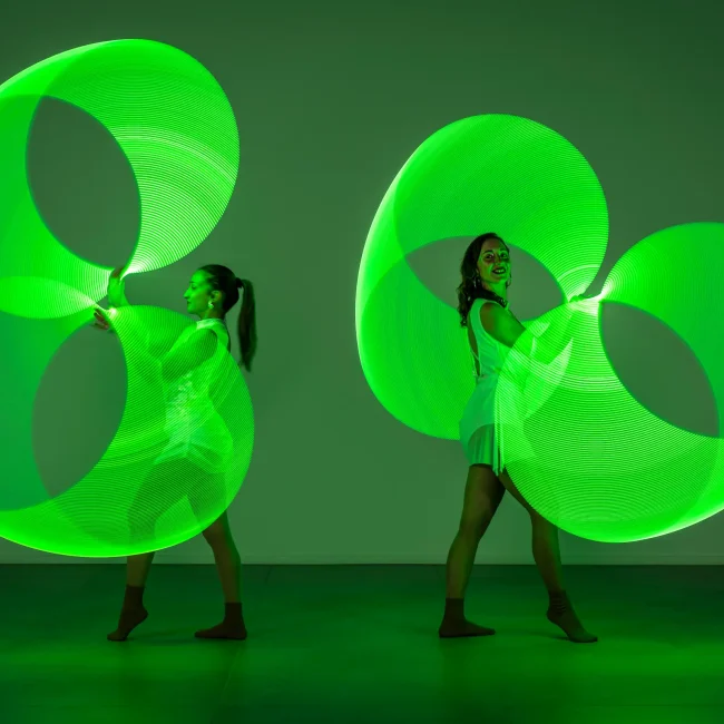 due ragazze del team di artharex si esibiscono con led luminosi verdi