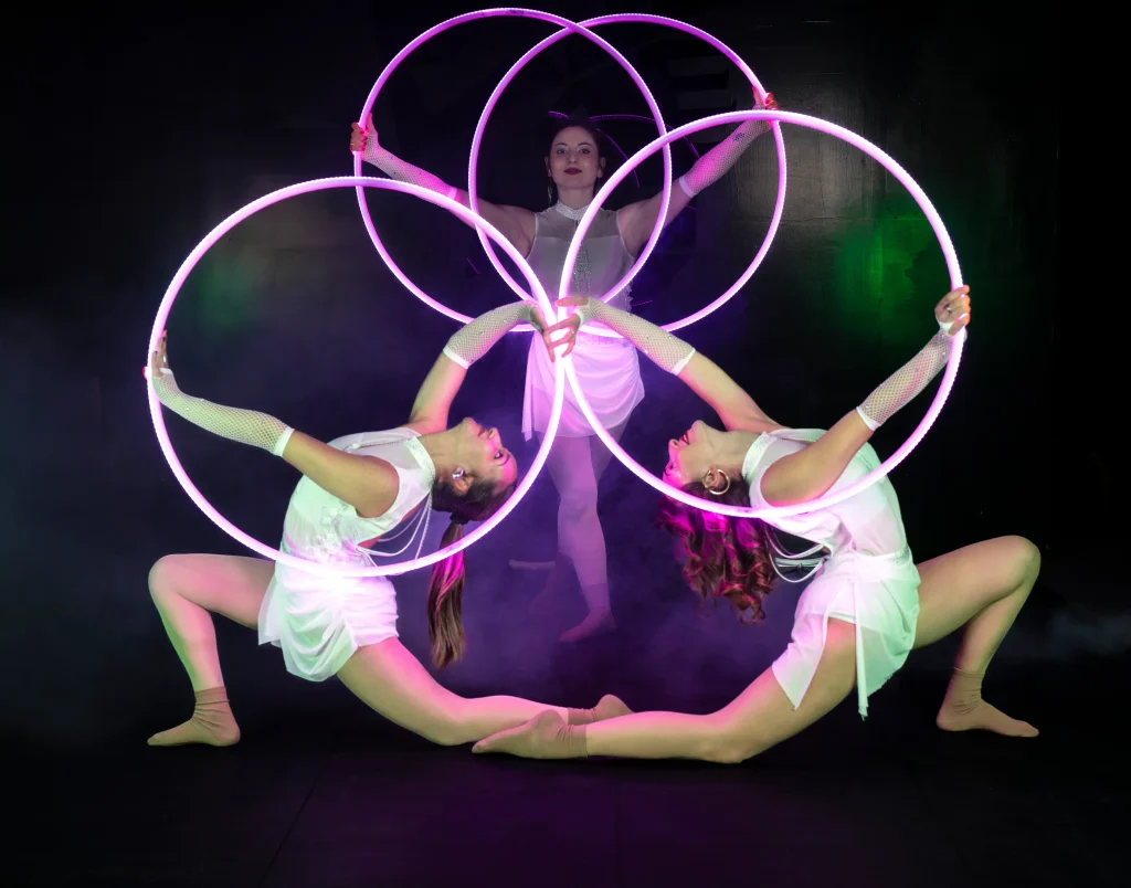 tre ragazze del team di artharex in posa con cerchio luminoso led laser e in posa da ginnaste