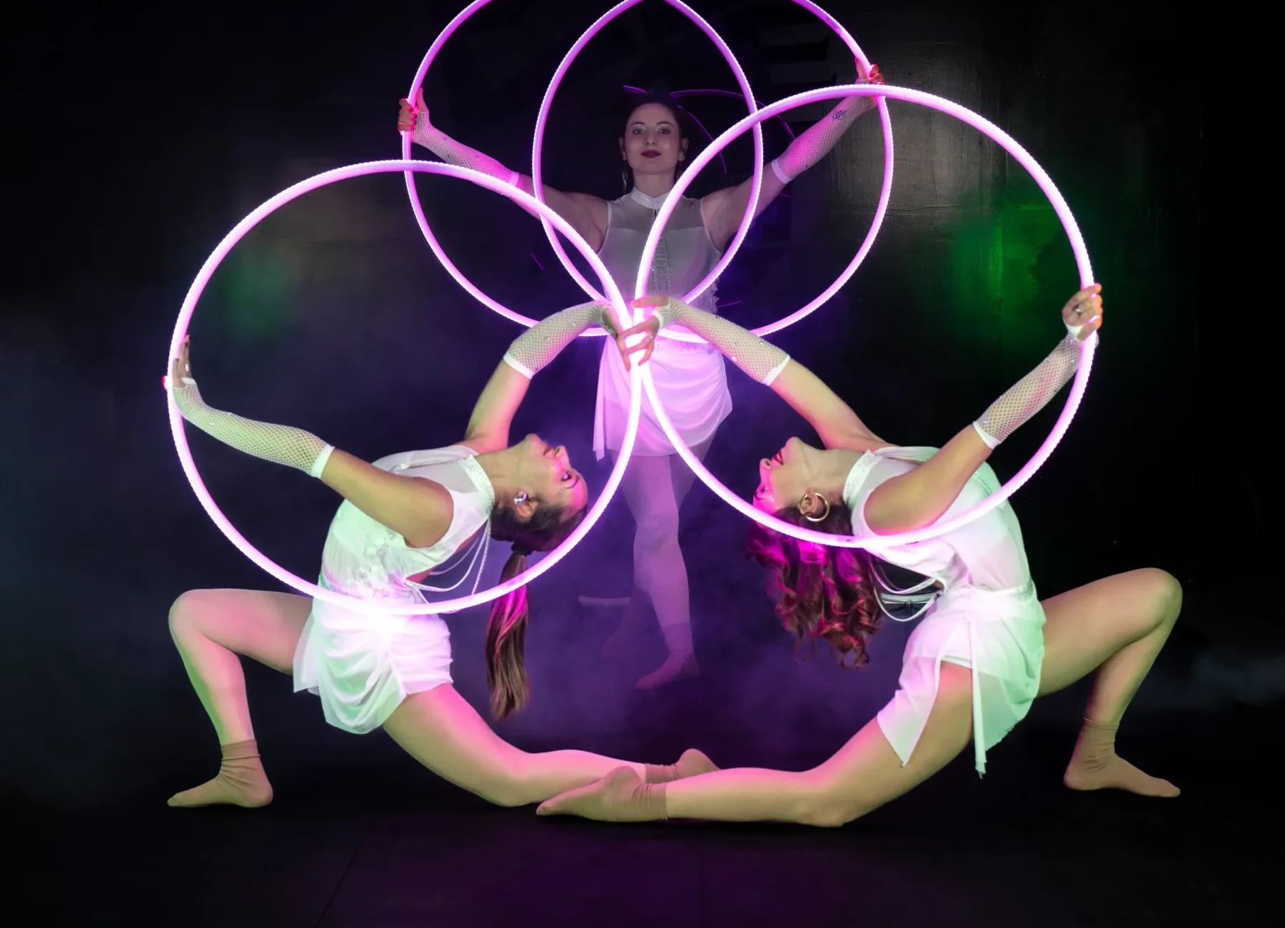 tre ragazze del team di artharex in posa con cerchio luminoso led laser e in posa da ginnaste