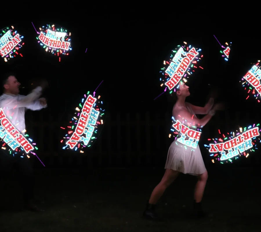 elvis e la sua compagna durante uno spettacolo con led le luci per un compleanno. Le luci creano la scritta Happy Birthday con dei coriandoli luminosi